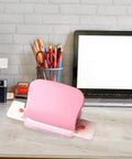 Pink six hole puncher for loose leaf notebooks on desk, handheld metal circle paper puncher with 5 sheet capacity.