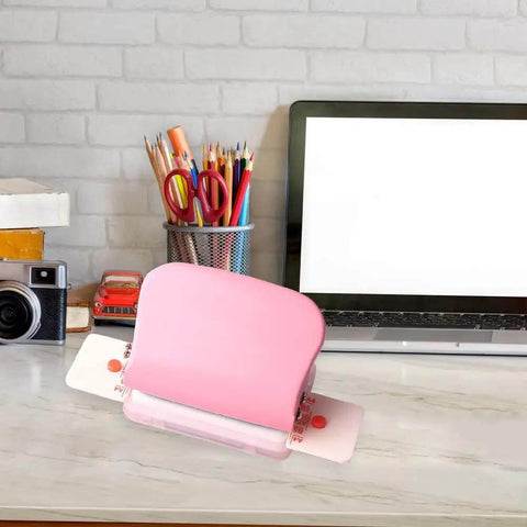 Pink six hole puncher for loose leaf notebooks on desk, handheld metal circle paper puncher with 5 sheet capacity.