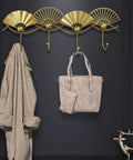 Top Shelf Golden Wall Mounted Coat Rack Featuring Tough Fan Shaped Hooks Rust Resistant Steel with coats and bags.