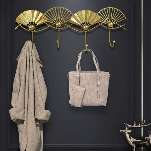 Top Shelf Golden Wall Mounted Coat Rack Featuring Tough Fan Shaped Hooks Rust Resistant Steel with coats and bags.