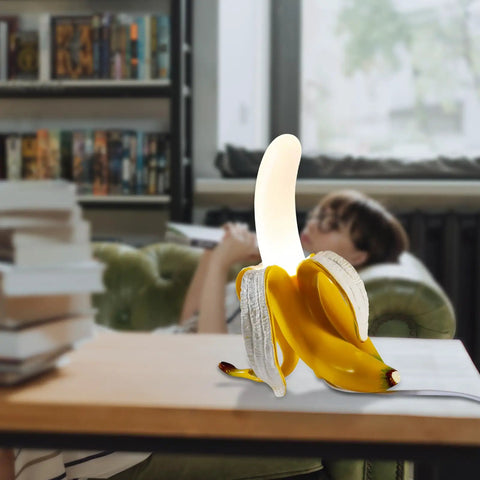 Dope Banana Table Lamp With LED Night Light, Modern Resin Banana Lighting Fixture on desk in living room, frosted acrylic shade.