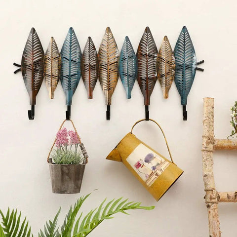 Hella Sturdy Wall Mounted Coat Rack With Reinforced Hooks For Clothes Hats And Robes Totally Multipurpose Entryway Organizer showcasing leaf-shaped hooks with potted plants attached.