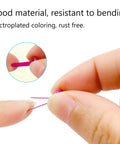 Close-up of a person bending a pink pin from the 100 Piece Brass Paper Fasteners Set Multicolor Mini Brads For Paper Crafts DIY Projects Pins For Crafts Lovers Sturdy No Rust Easy Bend Durable Metal Fasteners For Scrapbooks