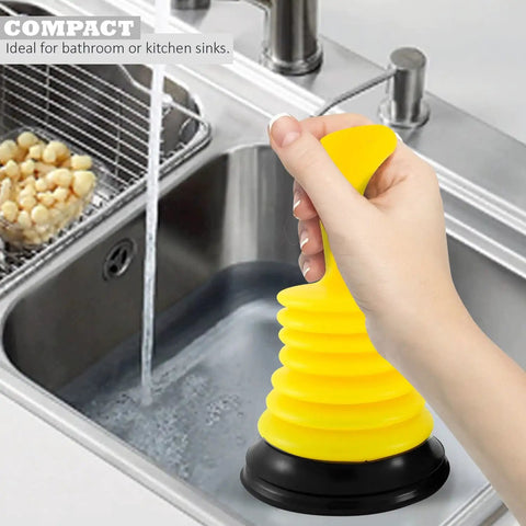 Hand holding a bright yellow Tiny 7 Inch Sink Plunger With Ergonomic Grip No Sweat Mini Clog Remover in kitchen sink