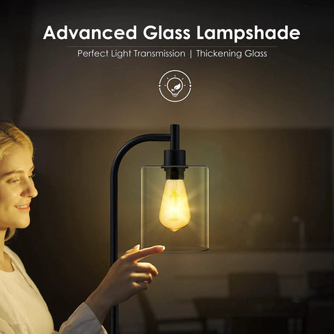Person adjusting modern industrial floor lamp with glass shade, showcasing warm 2700K LED glow for cozy living room or bedroom.