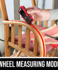Person using 65 Feet Laser Distance Measurer With Wheel Measuring Mode For Uneven Surfaces on a chair armrest