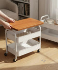 Three Tier Rolling Side Table With Lockable Casters And Spacious Storage Shelves For Hassle Free Room To Room Moving, showcasing wooden top and three white metal baskets.