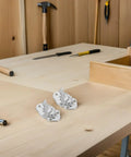Two Ten Pack Heavy Duty Silver Iron Toggle Latch Sets With Spring Loaded Closure on a wooden workbench with tools visible in the background.
