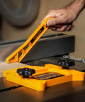 Hand using Two Piece Universal Featherboard And Magnetic Push Stick Safety Kit For Table Saws Router Tables And Jointers Keeps Your Shop Safe And Your Cuts On Point Every Cut
