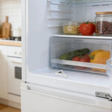 Close-up of 8 Pack Aluminum Shelf Clips for Fridge and Freezer on refrigerator shelf with fresh produce inside