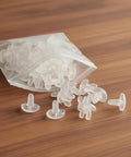 Premium Drapery Track Stoppers Keep Your Curtains Locked Down Totally Slip Free Tough Snap Install For Narrow Window Channels Perfect For Rental Turnovers And Quick Home Fixes, pack of clear plastic curtain glides on a wooden surface.