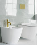 Ivy Bidet Faucet Brushed Gold Solid Brass Build Easy One Hole Install 1.2 GPM Flow Single Handle Hot Cold Control slick modern bath fixture next to a white toilet in a stylish bathroom.