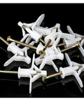 Scattered screws and wall plugs from a 50 Piece Drywall Fasteners Kit With Zinc Plated Screws, Nylon Plugs, Butterfly Wall Anchors For Hollow Walls