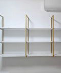 Heavy Hitter Gold Floating Shelf Brackets For Wall And Ceiling Wrought Iron support hooks showcasing white shelves mounted on a wall.