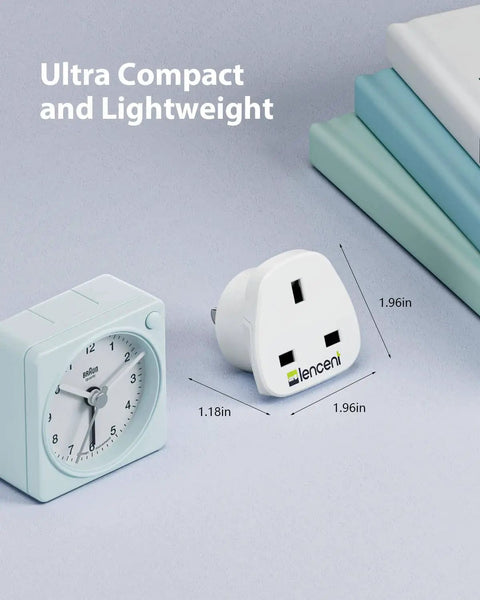 UK To US Plug Adapter 2 Pack Go-To Grounded Travel Converter next to clock for size comparison