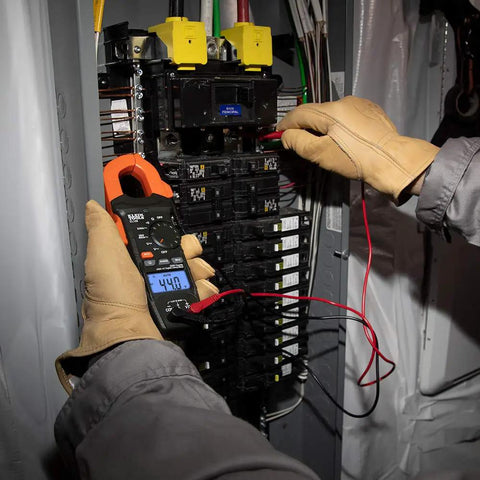 Electrician using Digital Clamp Meter With Auto-Ranging 400 Amp AC, Measures AC/DC Voltage, Resistance And Continuity on panel.