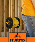 Heavy Duty Wire Dispenser For Stud Framing Mounts To 2x4 And 2x6 Wood Studs With Solid Steel Construction Delivers Fast Load No Fuss Payout For Reels Coils And Cables Made In USA in use with yellow wire spool.
