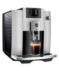 Premium Automatic Espresso Machine In Sleek Platinum Finish Packs In One Touch Brewing with glass of brewed coffee.