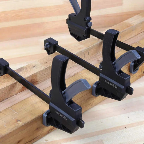Four Six Piece Easy To Use One Handed Trigger Clamp Set With Four Inch And Six Inch Clamps In Black And Grey Includes Two Four Inch Clamps And Four Six Inch Clamps Built Tough In Durable Nylon With Hardened Steel Bars And Non Marring Grippy Pads installed on wooden boards