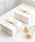 Decorative Metallic Bakers String Gold Twine 110 Yards 1.5mm Inelastic Glitter String on white gift boxes with roses
