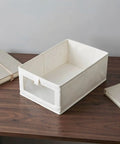 Heavy Duty Cotton Linen Foldable Storage Bins Stackable Closet Organizers on a wooden table with books.