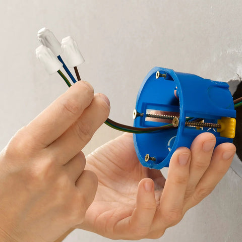 ANCIRS ceramic wire connectors; white caps on brown, blue, and green-yellow wires near a blue round electrical box