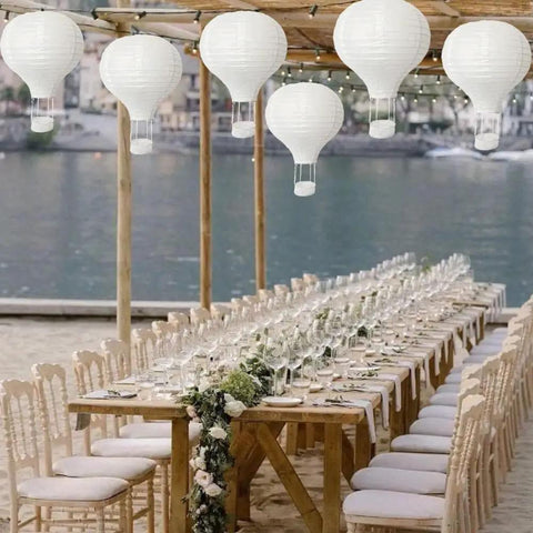 Outdoor event setup with 10 Pack White Hanging Hot Air Balloon Paper Lanterns 12 Inch Party Ready DIY Decor above a banquet table
