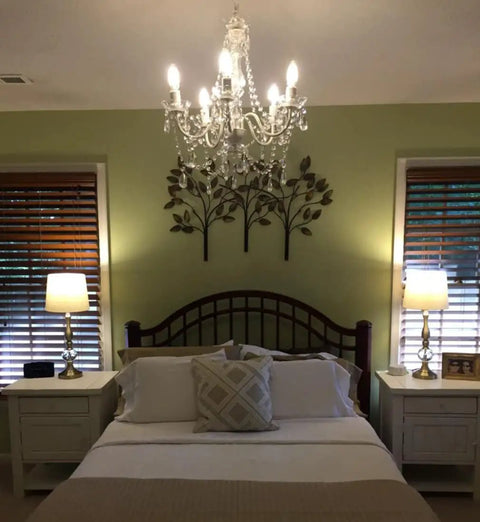 Plug-In Five Light Crystal Chandelier Swag Hanging Fixture with White Metal Frame and Clear Glass Stems above bedroom bed