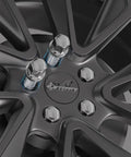 20 Piece Street Ready Chrome Lug Bolts M12 X 1.25 Thread With Rock Solid 28mm Shank And 17mm Hex Head Featuring Conical Seat Built Tough For Jeep Cherokee Compass Renegade Dodge Models on a black alloy wheel.