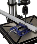 Rock Solid Drill Press Vise With Four Inch Jaw Width And Heavy Duty Clamping Force securing metal piece for precise drilling.