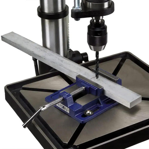 Rock Solid Drill Press Vise With Four Inch Jaw Width And Heavy Duty Clamping Force securing metal piece for precise drilling.