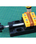Close-up of Mini Flat Clamp Bench Vise for watch repair and jewelry DIY holding a round object, showcasing precision and design