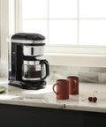 12 Cup Drip Coffee Maker With Spiral Showerhead And Programmable Keep Warm Plate For Rich Consistent Brews Every Time Onyx Black KCM1209 on kitchen counter