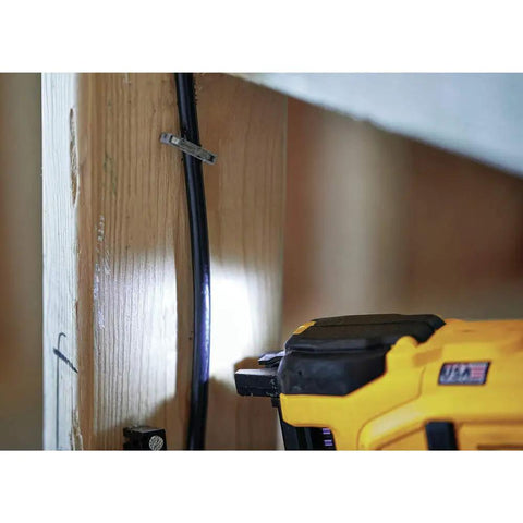 20V Cordless Stapler Kit For Cables With Center LED Light in use on wooden beam securing cable with staple