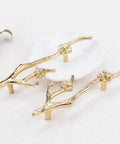 Slick Twig Drawer Pulls In Polished Brass Plum Blossom Branch Handle For Cabinets And Dressers, shown on light surface.