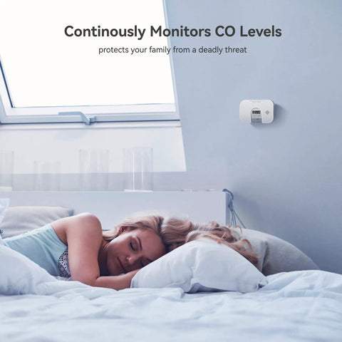 Carbon Monoxide Alarm Detector With 10 Year Life mounted on bedroom wall monitoring CO levels above sleeping person.