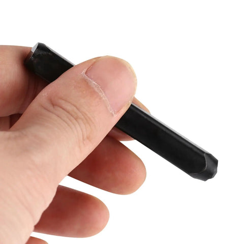 Hand holding a carbon steel stamp from Pro Grade Metal Stamping Kit With Carbon Steel Stamps 3mm Alphabet And Number Punches Hard Case Leather