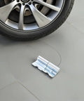 Heavy Duty Left Side Truck Cargo Box Panel Hinges two sets placed near a car tire on a gray surface.