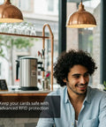 Man sitting in a cafe smiling, emphasizing urban lifestyle for Ultra Slim RFID Blocking Wallet For Men With Money Clip Carbon Fiber Build Lightweight Yet Durable Minimalist Card Holder For Everyday Carry Rugged And Refined Front Pocket Essential For Modern Dudes On The Go