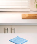 Reusable Kitchen Wipes, 60 Count, Rinse and Reuse Up to 10 Times on a kitchen counter with window and cutting board in background.