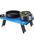 Blue Ultralight Folding Beach Table for camping and picnics, aluminum, 16x11x5 inches, holding a kettle and pan, sturdy 88 lbs capacity.