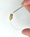 Hand holding a cleaning needle next to a brass 3D printer nozzle from the Complete 42Pcs 3D Printer Nozzle Cleaning Tool Kit.