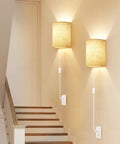 Plug In Wall Sconces Set Of Two With Three Adjustable Color Temperatures And Built In Switch For Hassle Free Plug And Play Lighting That Brings Solid Vibes To Your Space, beige fabric shades on wall.