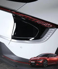 Badass Slick EV Charging Port Panel Trim Cover For Hyundai Kia EV6 2022 To 2026 mounted on a white EV, showcasing premium black finish.