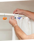 Person hanging Halloween Shower Curtain Hooks Bat Pumpkin Ghost Design 12 Piece Set With Smooth Glide No Snag Metal Rings