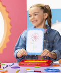 Child displaying art created with Jumbo Spiral Gear Art Kit for Kids 3 And Up, featuring retro spiral style drawing with easy grip gears.