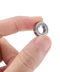 Close-up of Deep Groove Ball Bearings Set 5x8x2.5mm for Rollers and Skateboards held between fingers, double metal seals visible.
