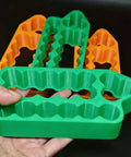 A Lightweight Battery Spot Welding Fixture That Delivers Boss Level Precision For Handling 18650 Or 21700 Lithium Cells, green and orange plastic jig.