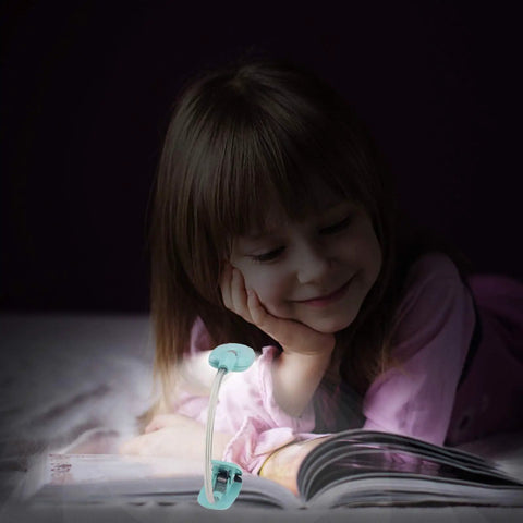 Child reading with Kids Clip On Reading Light 3 Pack Battery Operated Dimmable Lamp, flexible neck, kid-friendly design.
