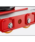 Close-up of the red motorized machinery dolly's durable structure, showcasing pivot turntable, wheels, and connection points.